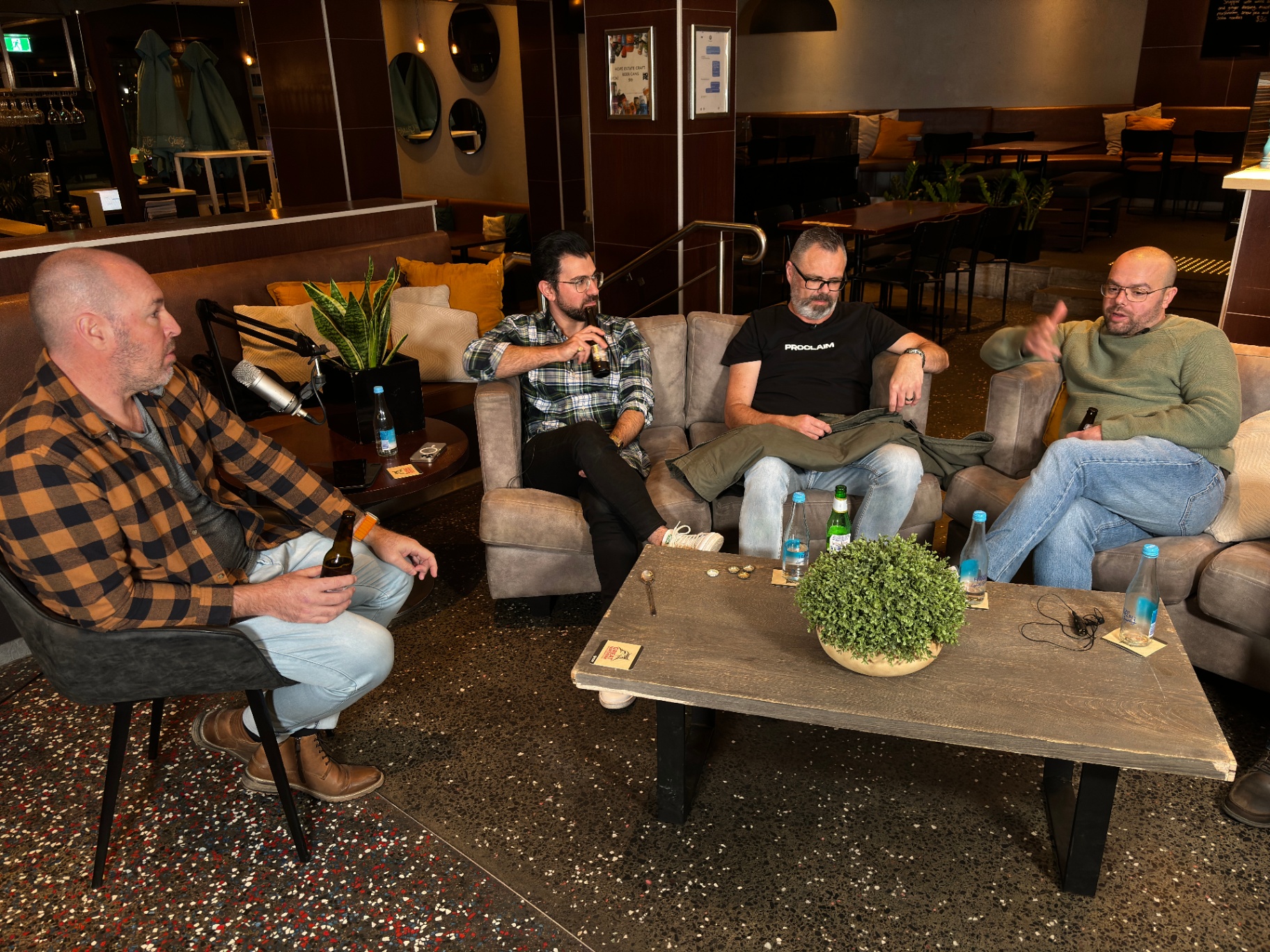 A group of men talking together in a relaxed lounge setting.
